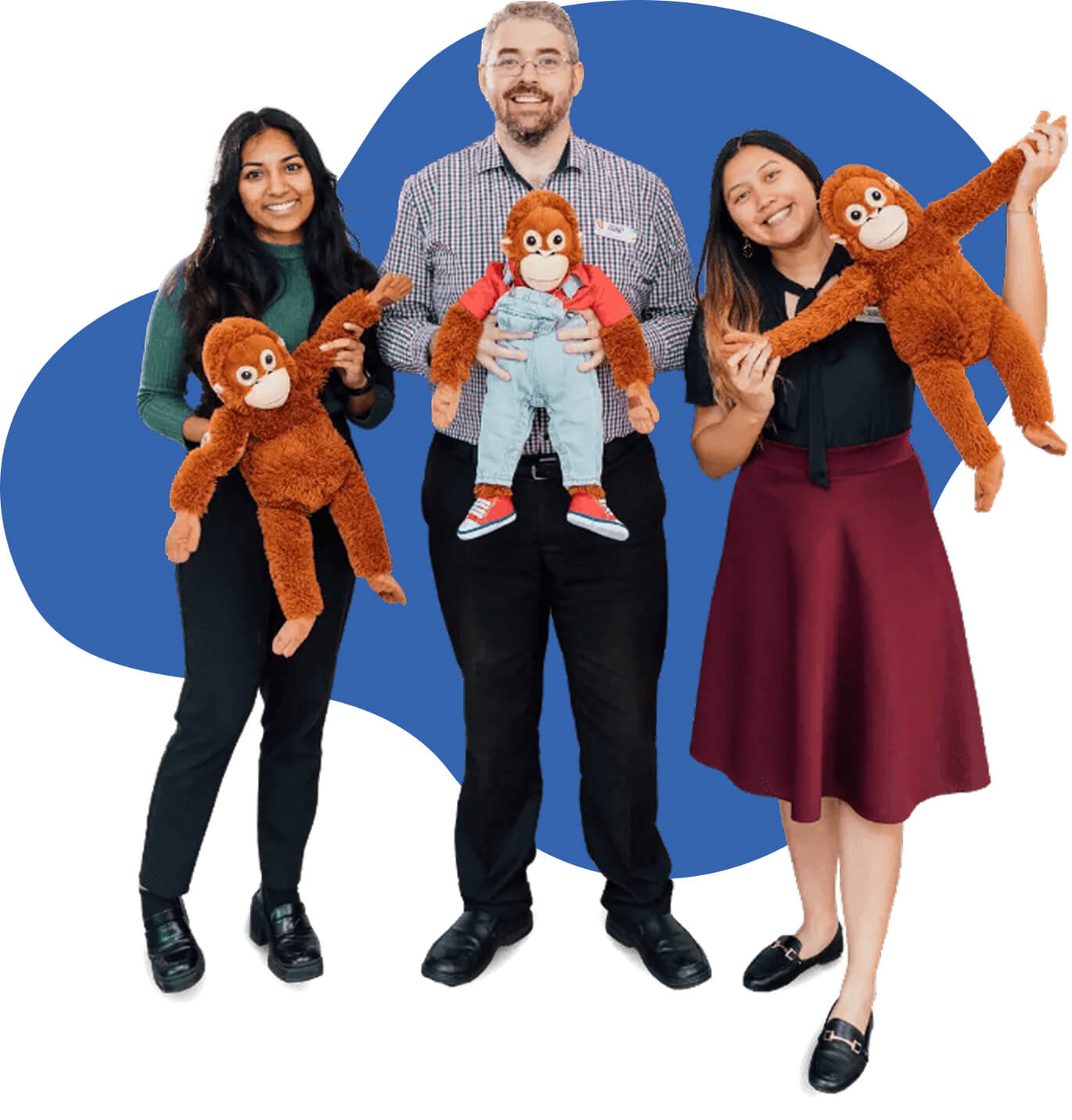 Photo of three staff members holding toy monkeys of George the mascot
