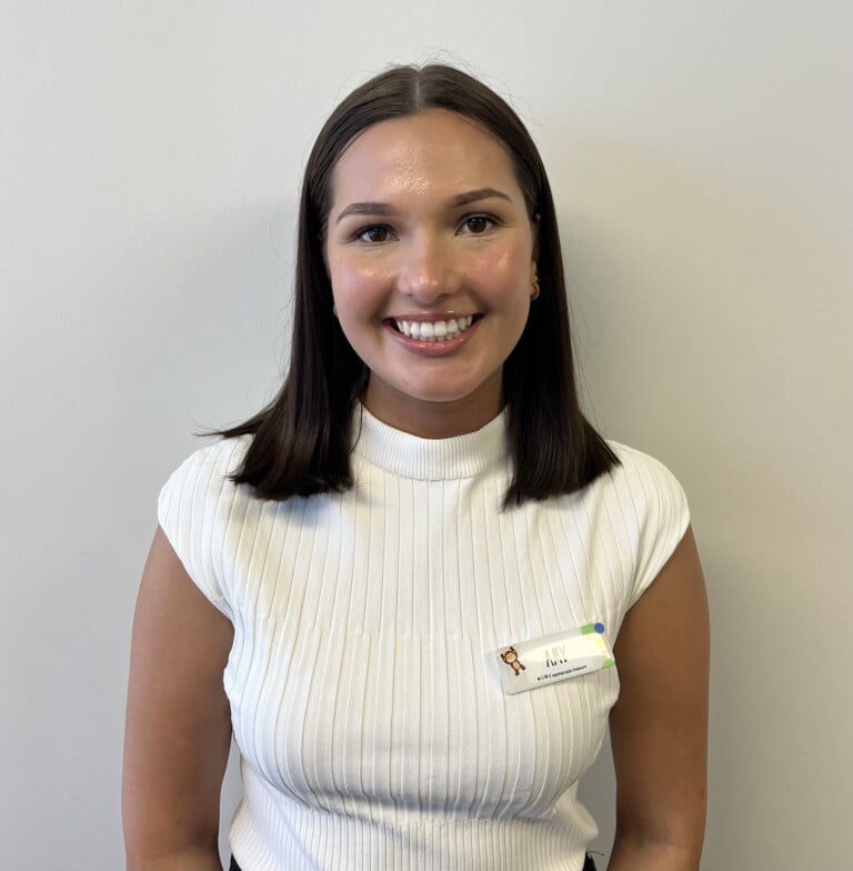 A smiling woman in a white shirt, Amy Casas, radiating positive energy.